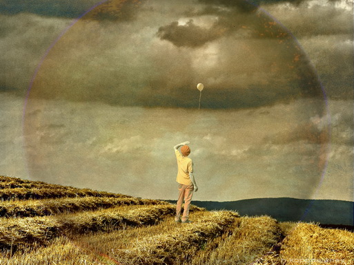 A person in a field waching a bubble.
