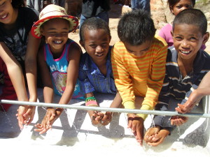 Children test out the new water supply at their school. Photo: Money for Madagascar