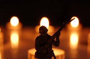 A toy soldier in front of tea lights