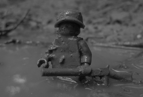 A lego soldier up to his waist in mud