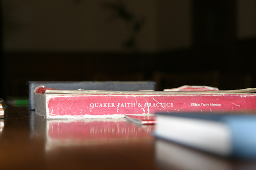 A well-worn copy of Quaker Faith & Practice lying on a table