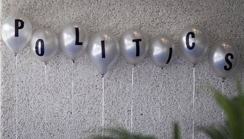 Balloons, each with a letter on them, spelling out 'politics'